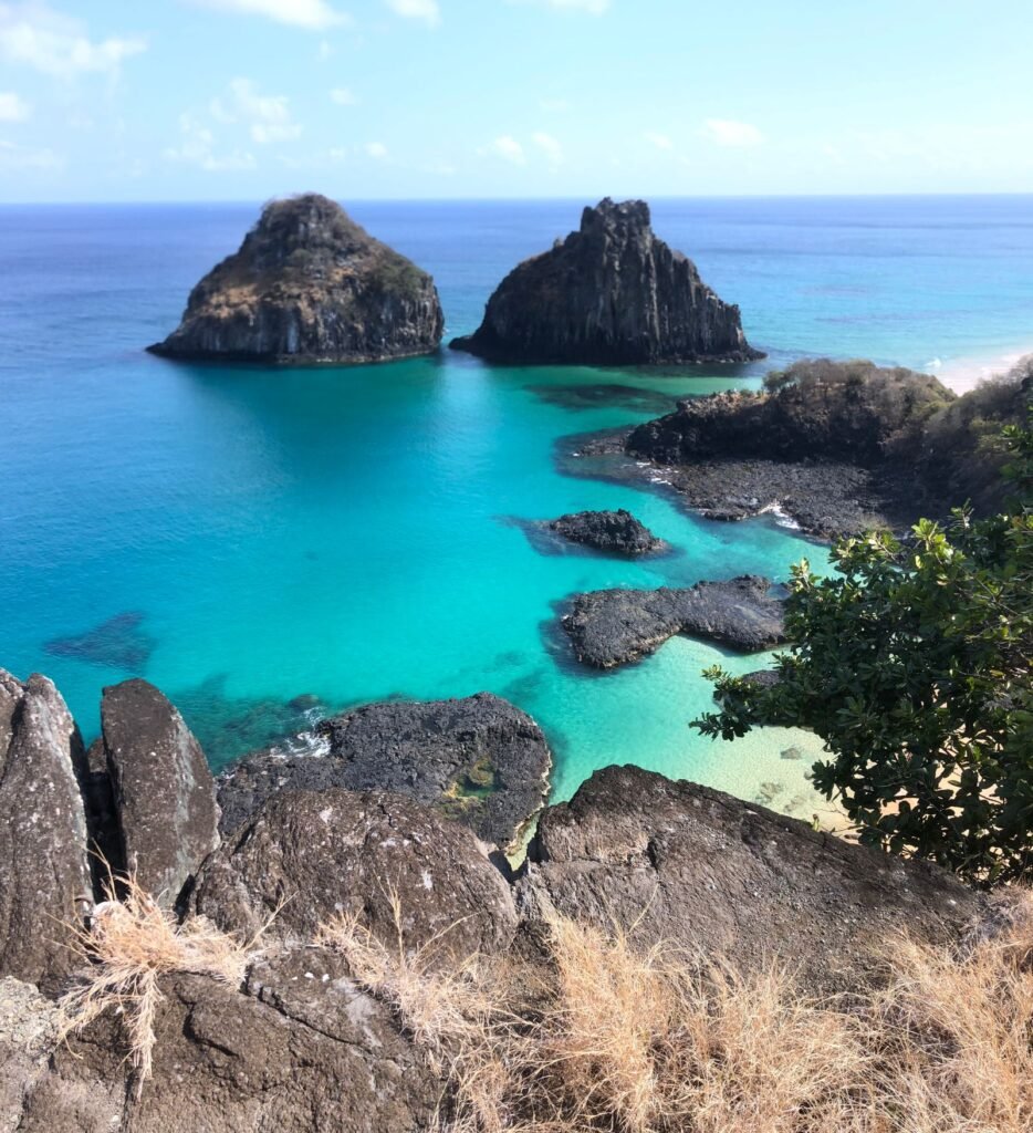 Água do mar turquesa transparente junto a formações rochosas costeiras