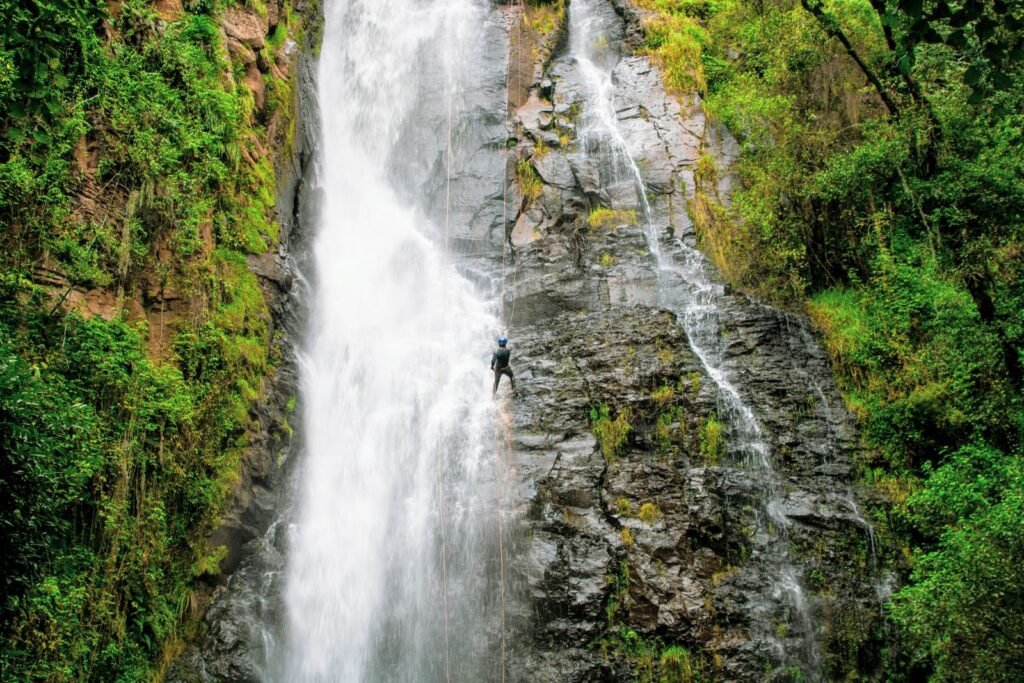 Aventureiro descendo cachoeira com cordas